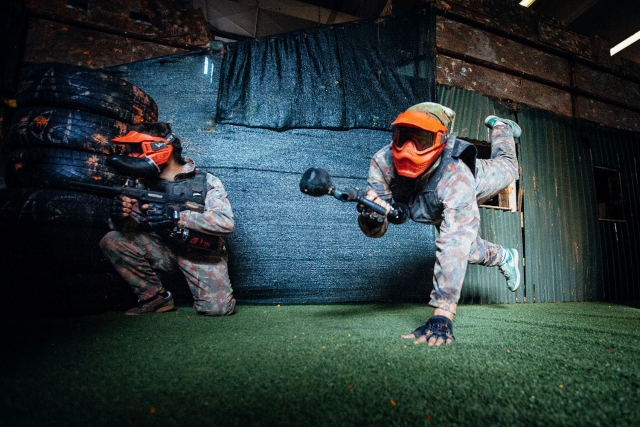  Deux joueurs essayant de l'atteindre victoire sur le terrain de jeu au Paintball Arena