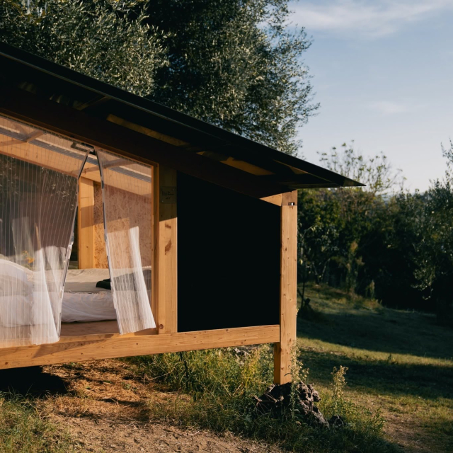 Tende bianche e letto tra gli ulivi