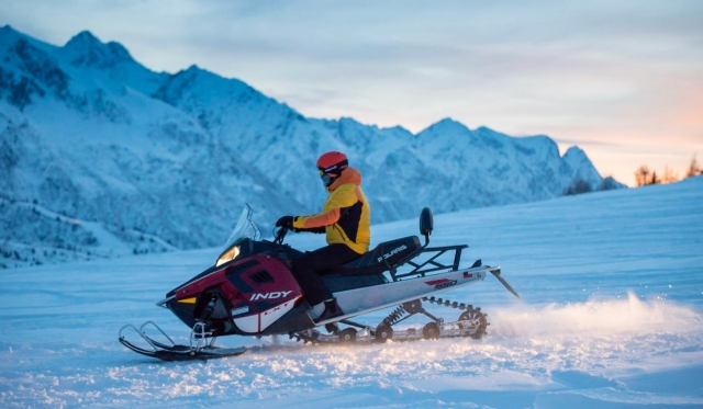  em um snowmobile ao pôr do sol