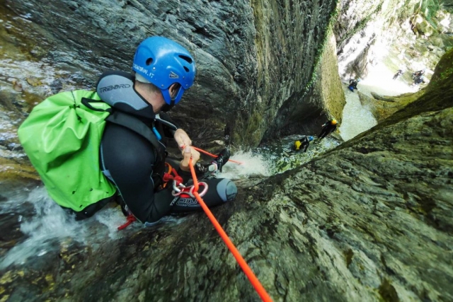  Der Athlet lässt sich in den Bach hinab 
