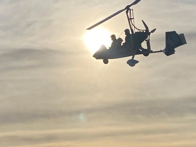 Tragschrauber fliegen bei Sonnenuntergang 