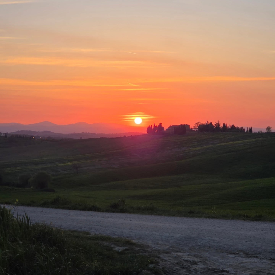 Il sole che tramonta sulla strada bianca